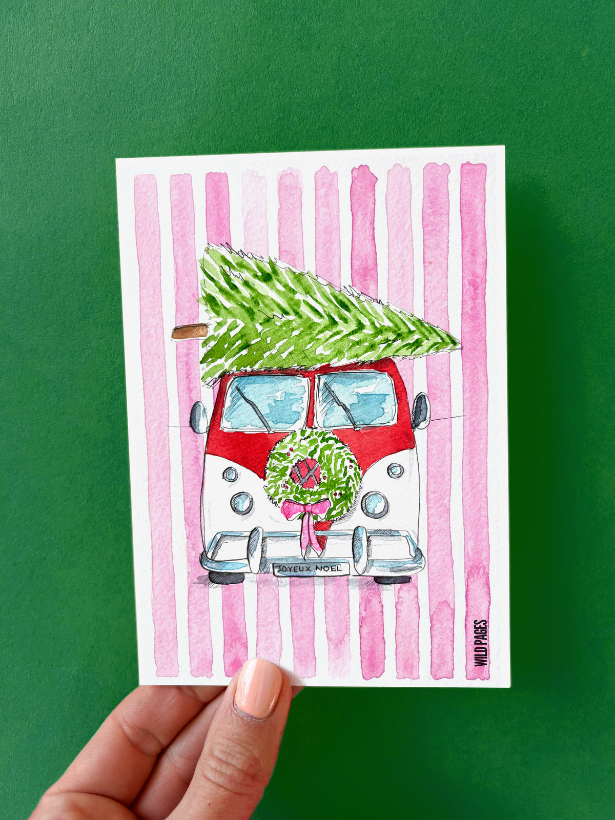 Illustration aquarelle d'un van rouge et blanc portant un sapin sur son toit, couronne à l'avant, fond à rayures roses.